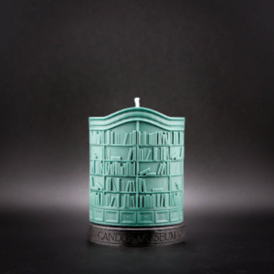 Teal candle shaped like a bookshelf on a dark background