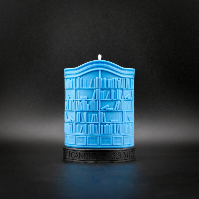Blue candle shaped like a bookshelf on a dark background